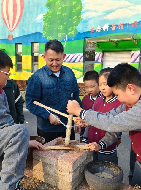 沈撫育才實驗學(xué)校老師給學(xué)生們講解鉆木取火的科學(xué)原理.jpg