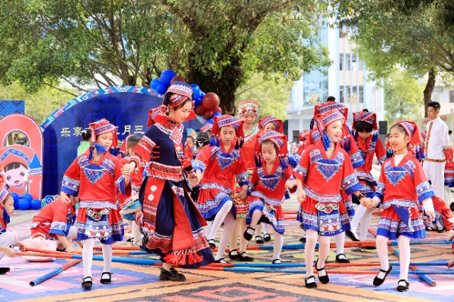 圖4：4月9日，在廣西柳州市融安縣實(shí)驗(yàn)小學(xué)校園，一名老師帶著學(xué)生跳竹竿舞。（譚凱興 攝）.JPG